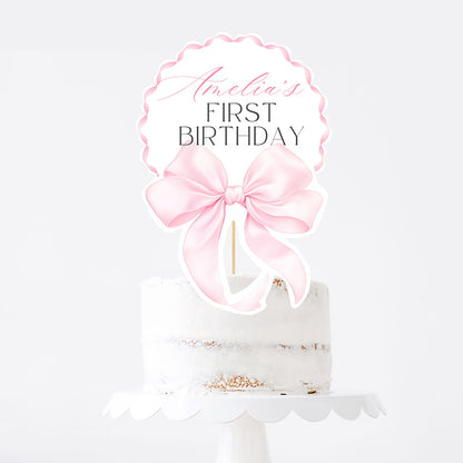Elegant pink bow topper for a girl’s first birthday. Editable Canva template, printable and perfect for cake or centerpiece decor.